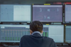 Man looking at screens in SOC room